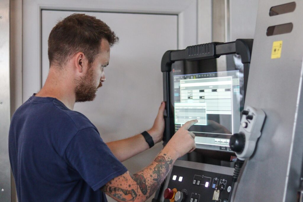 Working guy behind computer for machine